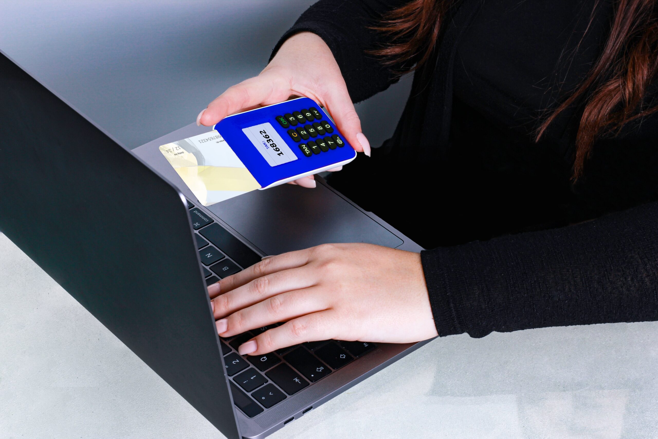 A women on her computer with a credit card processor in her hand
