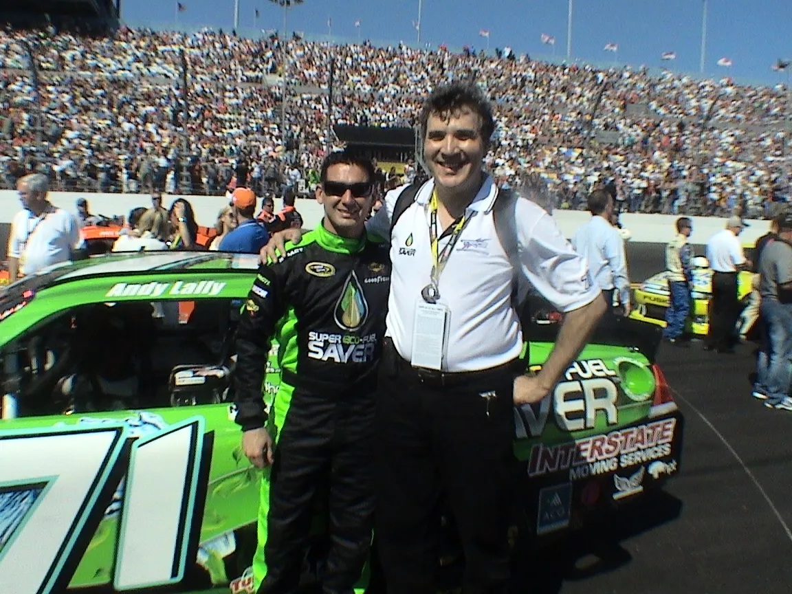 Driver Andy Lally in his firesuit standing beside the green No. 71 car on the Daytona grid