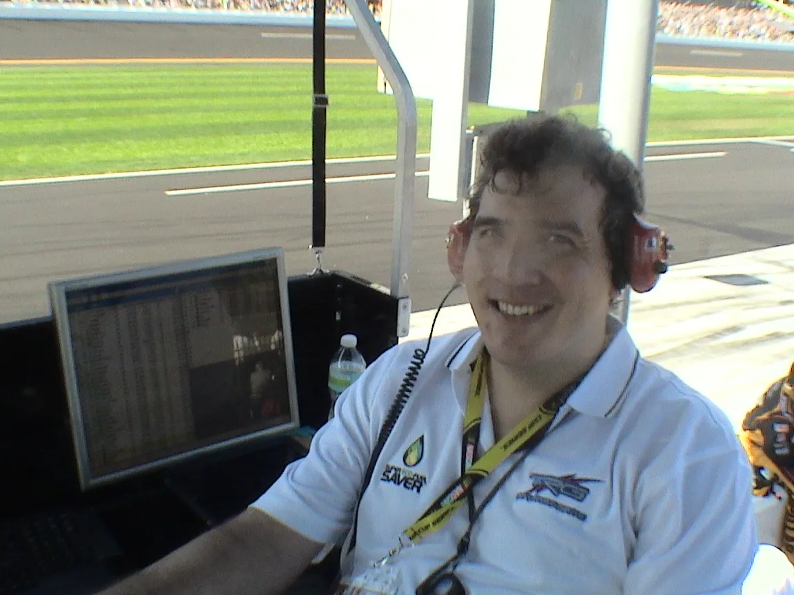 Team member wearing a headset in the No. 71 pit box at Daytona, next to a live timing monitor